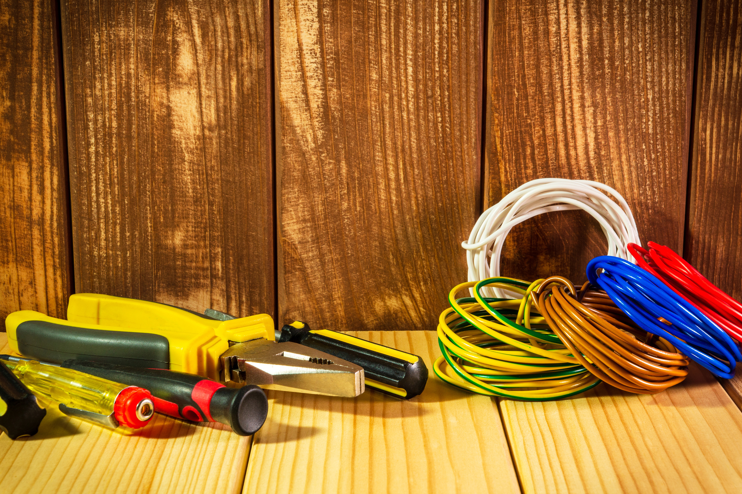 Professional tool for electrician on vintage wooden background.